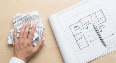 A top-down desk shot. On the left side, there is a messy, crumpled pile of papers with blurred text and generic buzzwords like "self-starter" and "guru." A hand is pushing this pile away. On the right side, there is a clean, brightly lit architectural blueprint unfurled. The blueprint shows clear diagrams with specific metrics like "30% Growth" and "Hire 4 Executives," marked with green checkmarks. A sleek pen rests on the blueprint. The aesthetic is clean, professional, and focused.