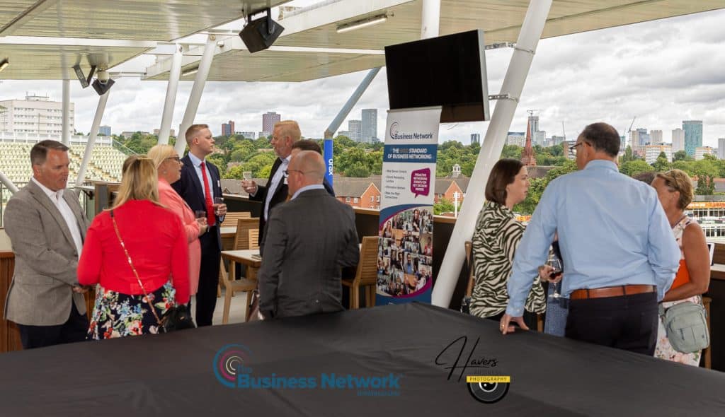 Diverse group of professionals networking warmly on a rooftop terrace